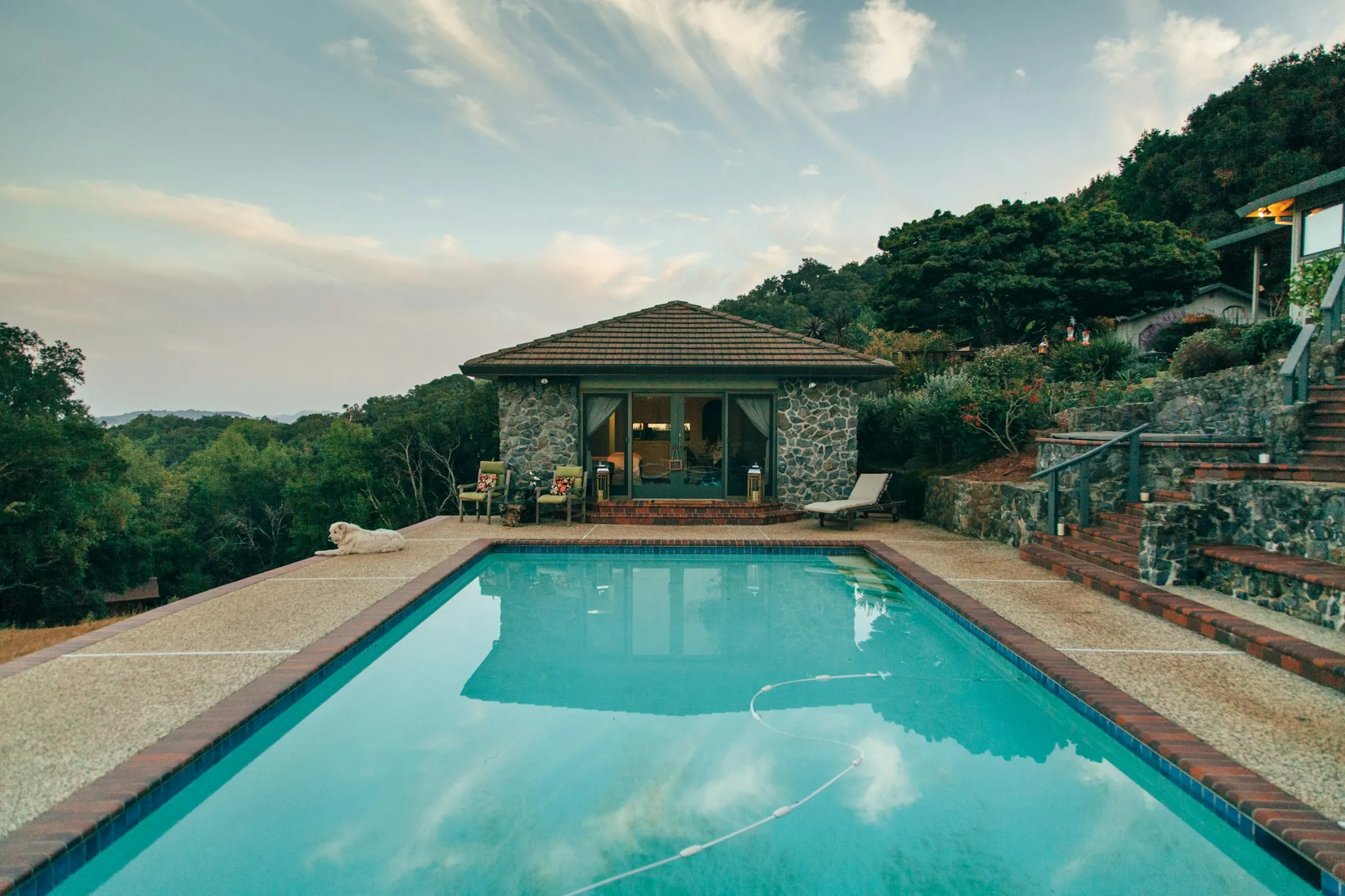 Piscina con pool house in pietra immersa nel verde