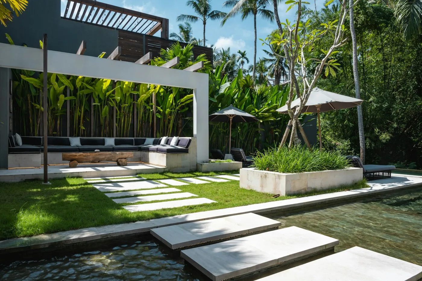 Piscina moderna con giardino e camminamento in pietra